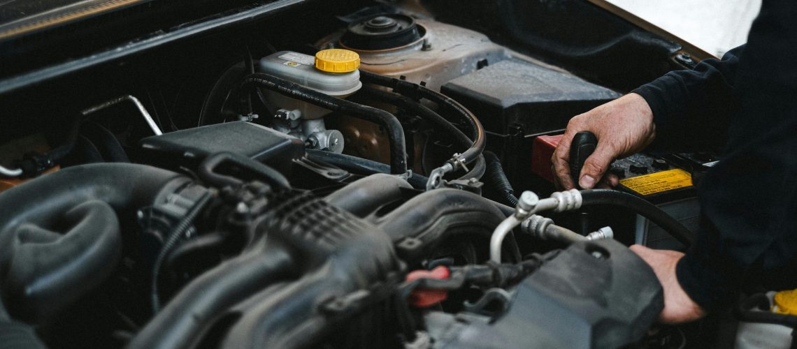 person working on engine under hood